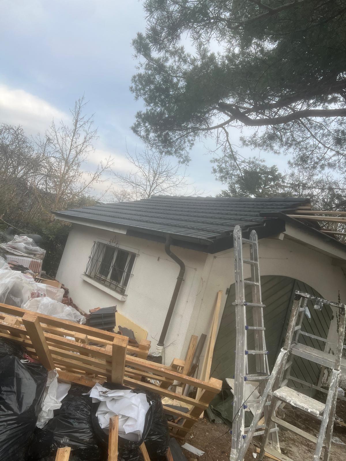 Toiture rénovée en tuiles anthracite sur une maison